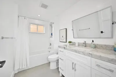 a white bathroom with a sink and a toilet at 5 Bedroom Luxury Duplex across from the Beach for 11 people in Newport Beach