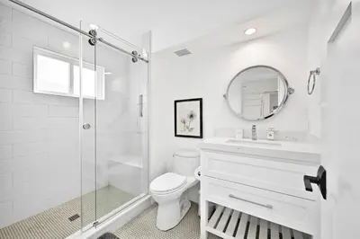 a white bathroom with a shower and a toilet at 4 Bedrooms in BRAND NEW Luxury built Home walk to the beach in Newport Beach