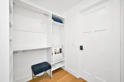 a white closet with a black chair next to a door at 4 Bedrooms in BRAND NEW Luxury built Home walk to the beach in Newport Beach