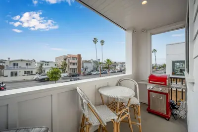 a balcony with chairs and a window with a view of a street at 4 Bedrooms in BRAND NEW Luxury built Home walk to the beach in Newport Beach