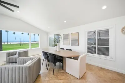a dining room with a table and chairs and a couch at 3 Bedroom with Park and Beach in your Backyard! in Newport Beach