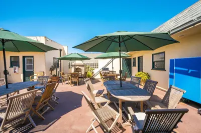 a patio with tables and chairs and green umbrellas at 514 E Oceanfront B in Newport Beach