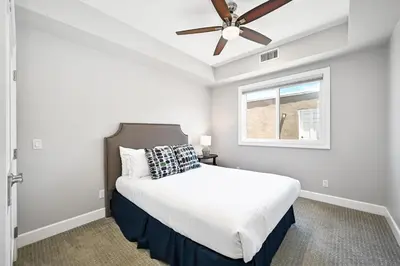 a bedroom with a bed and a ceiling fan at Upscale Home with Rooftop Deck, Jacuzzi, & Firepit in Newport Beach