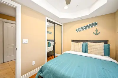 a bedroom with a bed and a sign on the wall at 50 Steps to the Sand on 39th St - Newport Beach in Newport Beach