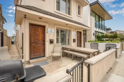 a patio with a wooden bench and a wooden door at 50 Steps to the Sand on 39th St - Newport Beach in Newport Beach