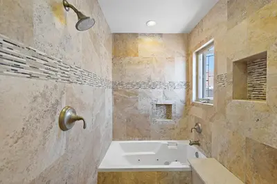 a large bathroom with a tub and a window at Modern Beach House Steps from the Sand on 39th St in Newport Beach