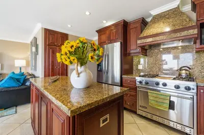 a kitchen with a vase with yellow flowers on a counter at 7 Bedroom Oceanfront Triplex Building in Newport Beach