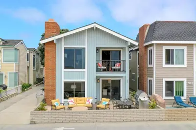 a house with a patio with chairs and a table at 7 Bedroom Oceanfront Triplex Building in Newport Beach