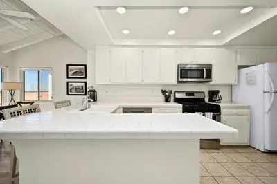 a kitchen with white cabinets and a white counter top at Beachfront home with Sweeping Ocean Views, AC, Walk to the Pier, Restaurants, Shops, Activities in Newport Beach