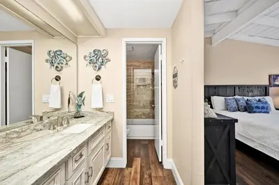 a bathroom with a sink and a bedroom with a bed at Stunning Oceanfront Retreat in Newport Beach in Newport Beach