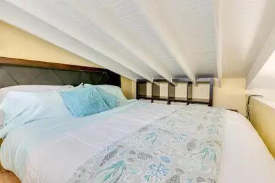 a bedroom with a large white bed with blue pillows at Carlsbad Bungalow Patio, Hot Tub, Close to Beach! in Carlsbad
