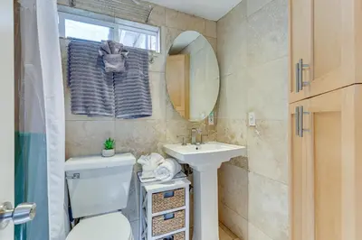 a bathroom with a toilet and a sink and a mirror at Carlsbad Bungalow Patio, Hot Tub, Close to Beach! in Carlsbad