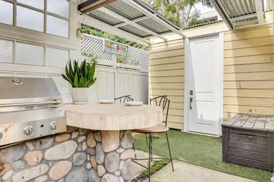 a patio with a wooden table and a grill at Carlsbad Bungalow Patio, Hot Tub, Close to Beach! in Carlsbad