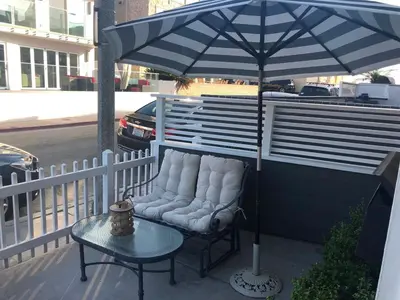 a chair sitting under an umbrella on a patio at Newport Beach House in Newport Beach