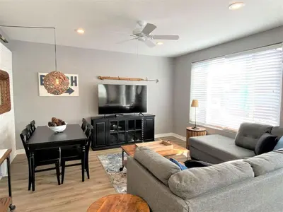 a living room with a couch and a table and a television at Newport Beach House in Newport Beach