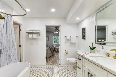 a white bathroom with a tub and a toilet and a sink at North San Diego Retreat with Deck, Fire Pit Table! in Escondido