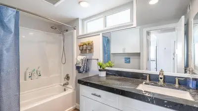 a bathroom with a sink and a shower and a tub at Ocean Breeze Buyout by AvantStay Steps to Beach in Newport Beach