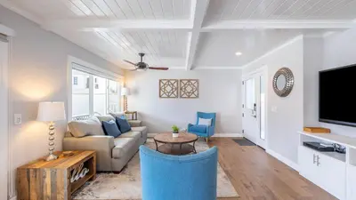 a living room with a couch and a tv at Ocean Breeze I by AvantStay Steps to the Beach in Newport Beach