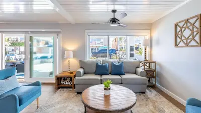 a living room with a couch and a table at Ocean Breeze I by AvantStay Steps to the Beach in Newport Beach