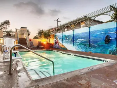 a swimming pool with a mural on the side of a building at Laguna Brisas - A Beach Hotel in Laguna Beach