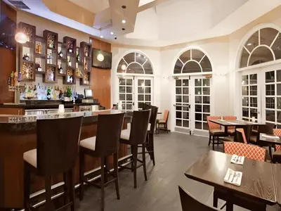 a restaurant with tables and chairs and a bar at Hotel San Diego-Rancho Bernardo in Rancho Bernardo