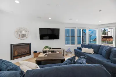 a living room with blue couches and a fireplace at The Mission Beach VIP- 3 Decks, AC, Steps to Sand! in San Diego