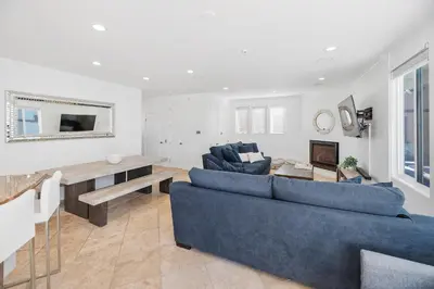 a living room with two blue couches and a table at The Mission Beach VIP- 3 Decks, AC, Steps to Sand! in San Diego