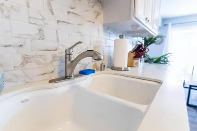 a kitchen sink with a white counter top at Cali Condo+BBQ+MemoryFoamBeds+12min to Beach in San Juan Capistrano