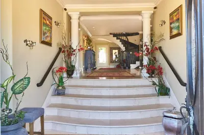 a staircase in a house with flowers on the walls at UNEQUALLED LUXURY VILLA BEACH 7000ft 180 VIEW in Laguna Beach