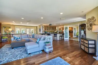 a living room with a blue couch and a kitchen at UNEQUALLED LUXURY VILLA BEACH 7000ft 180 VIEW in Laguna Beach