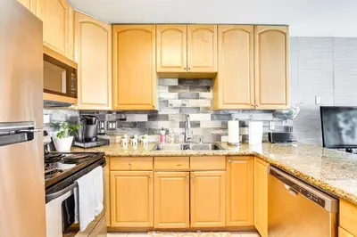 a kitchen with wooden cabinets and a sink at Updated Mission Beach Condo Walk to Belmont Park! in San Diego