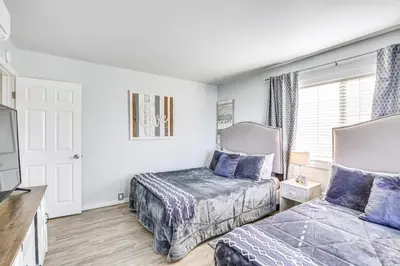a bedroom with two beds and a tv at Updated Mission Beach Condo Walk to Belmont Park! in San Diego