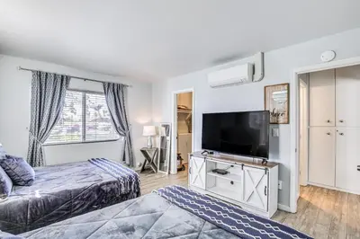 a bedroom with two beds and a flat screen tv at Updated Mission Beach Condo Walk to Belmont Park! in San Diego