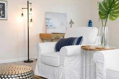 a living room with a white chair and a table at Perla D'Italia -1BR- FREE Driveway Parking -1 Car in San Diego