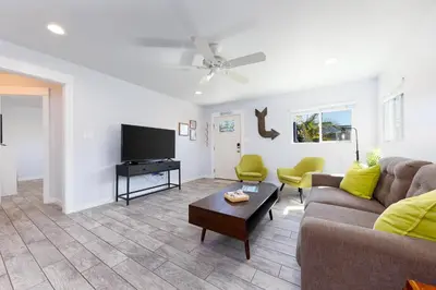 a living room with a couch and a flat screen tv at Charming Beach Bungalows - 4BR, Sleeps 10, Pets OK in Carlsbad