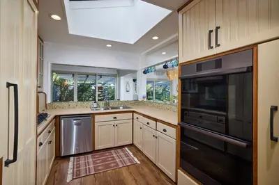 a kitchen with white cabinets and a black appliance at Family Beach house in Carlsbad