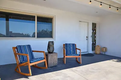two chairs sitting on a porch with a window at Family Beach house in Carlsbad
