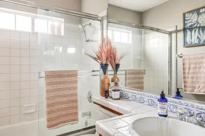 a bathroom with a tub and a sink and a mirror at Escondido Home Private Pool, 2 Grills and Fire Pit! in Escondido