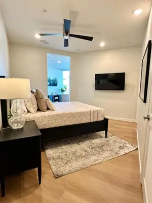 a bedroom with a bed and a flat screen tv at Nimitz Crossing Luxury Residences in San Diego
