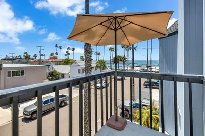 a balcony with an umbrella and a parking lot at Pine Street #2 in Oceanside