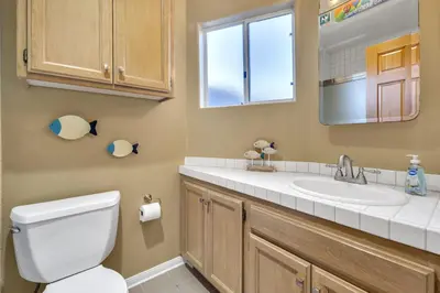 a bathroom with a toilet and a sink and a mirror at Pine Street #2 in Oceanside