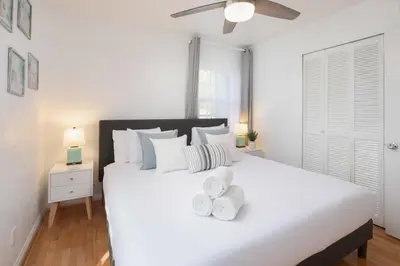 a white bedroom with a large white bed with two towels at 4 Bedroom 2 Bath with Ocean View Hot Tub Parking in San Diego