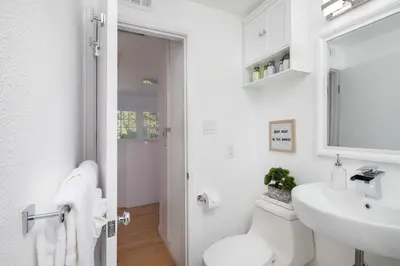 a bathroom with a sink and a toilet and a mirror at 4 Bedroom 2 Bath with Ocean View Hot Tub Parking in San Diego