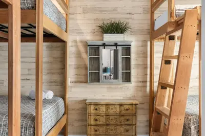 a bedroom with two bunk beds and a wooden wall at Good Life Resorts in San Diego