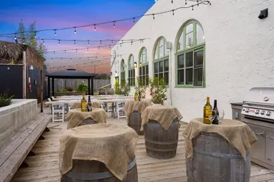 a patio with tables and chairs and wine bottles at Good Life Resorts in San Diego