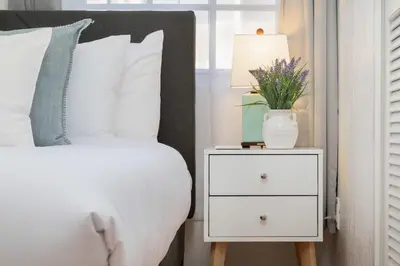a bedroom with a white bed and a night stand with a lamp at 3 Bedroom with Ocean View Jacuzzi and Parking in San Diego