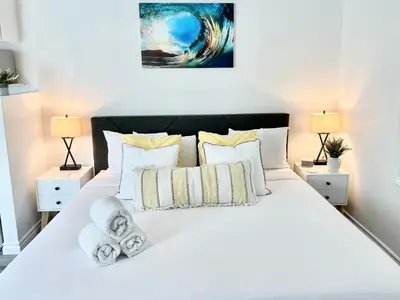 a bedroom with a large white bed with pillows at Hidden King Suite with Garden Parking - 4 Guest in La Mesa