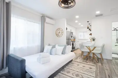 a white living room with a couch and a table at 2 Bedroom House - Fire Pit Table BBQ - Downtown in San Diego