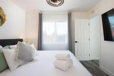 a white bedroom with a white bed and a window at 2 Bedroom House - Fire Pit Table BBQ - Downtown in San Diego