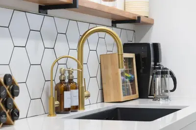 a kitchen counter with two gold faucets and a sink at 3 Bed House with Fire Pit Table and BBQ - Downtown in San Diego